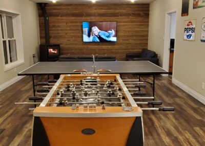Walkout games room (33x16) with foosball, ping pong, dart board, 65in Smart TV with Netflix, board games and new wood stove